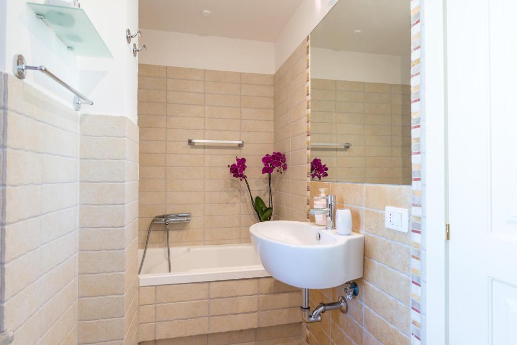 La salle de bains est pourvue d'un lavabo et d'une baignoire ornée de fleurs violettes. dans l'établissement Casale La Desdemona, à Sutri