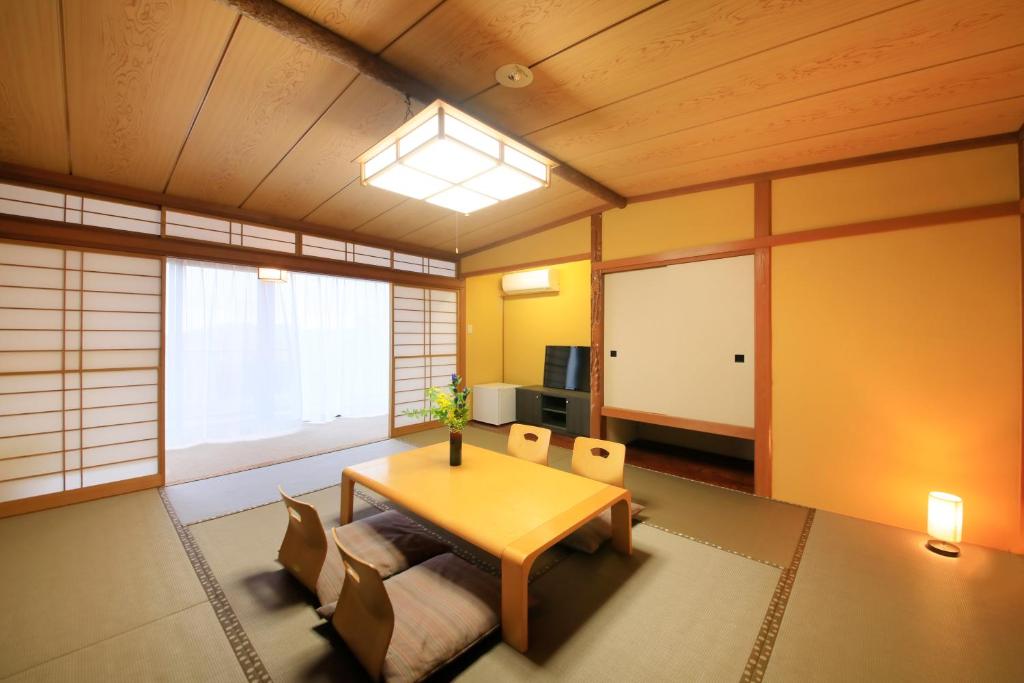 un salon avec une table et des chaises en bois dans l'établissement Atami Fuga, à Atami