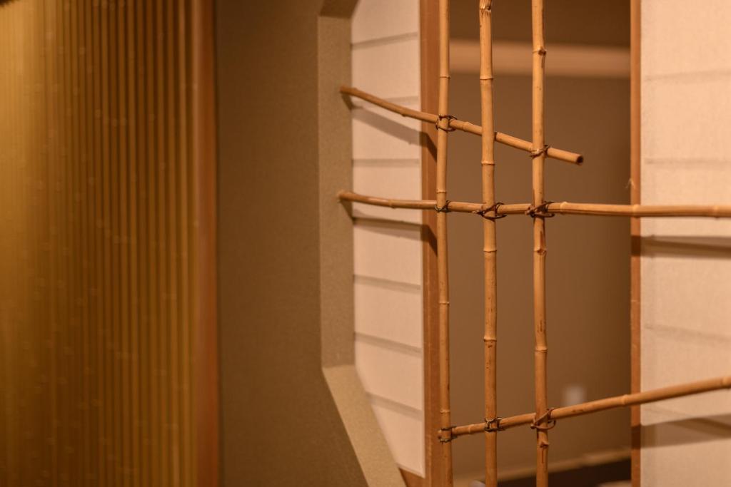 - un portant en bois dans une chambre dotée d'un mur dans l'établissement Atami Onsen Sakuraya Ryokan, à Atami
