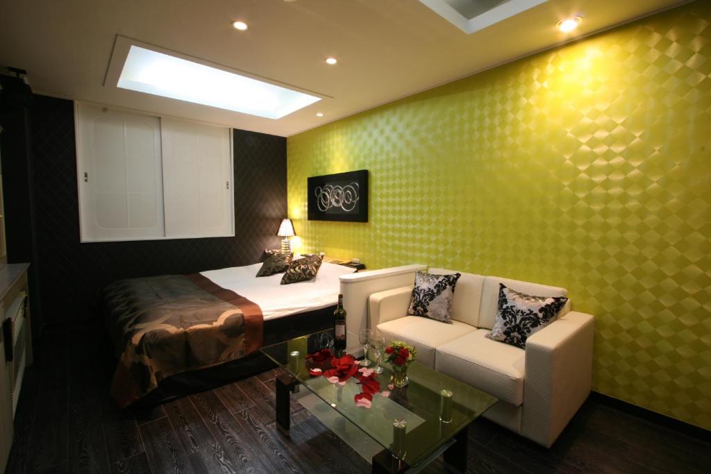 une chambre avec un lit, un canapé et une table dans l'établissement Restay Kokura (Adult Only), à Kitakyūshū