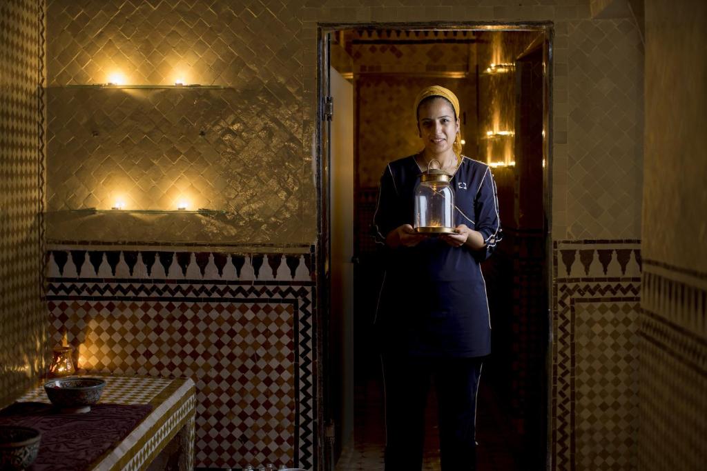 une femme debout sur une porte tenant un pot dans l'établissement Palais Amani, à Fès 37 autres photos