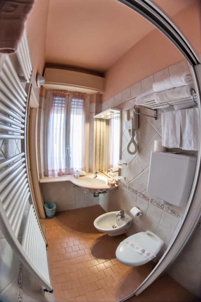 une salle de bain avec deux lavabos et un miroir dans l'établissement Hotel Angelini, à Rimini
