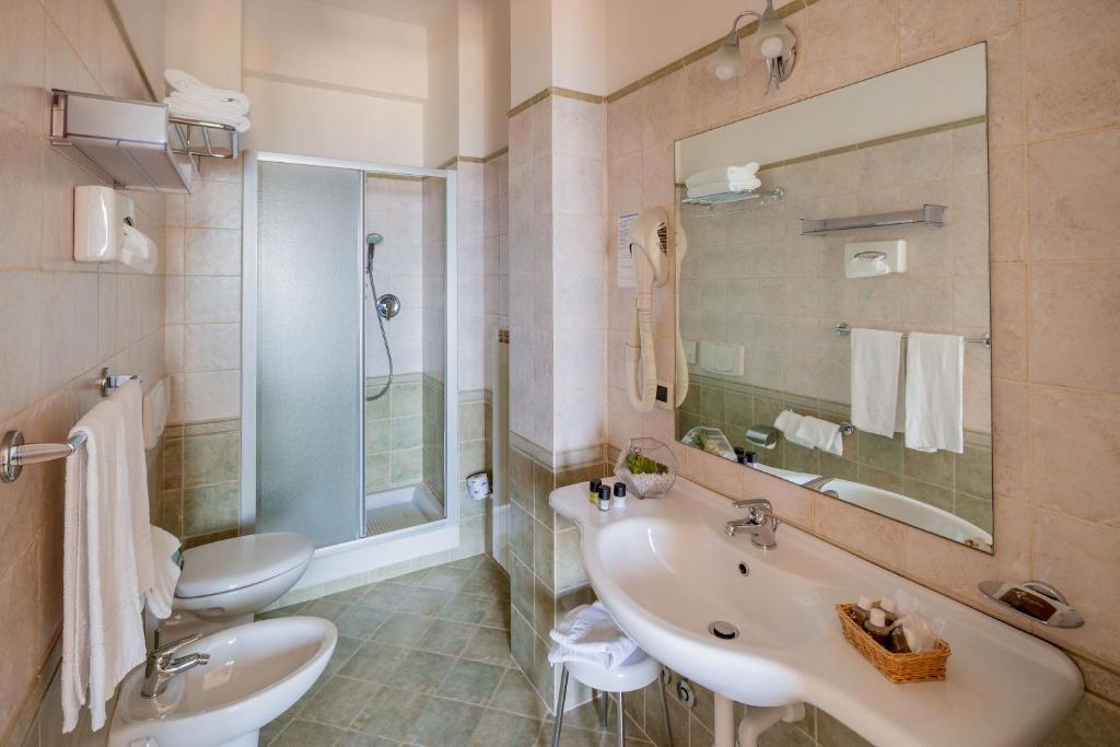 une salle de bain avec un lavabo, des toilettes et un miroir dans l'établissement Hotel Metropol, à Diano Marina