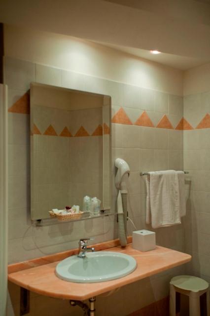 une salle de bain avec un lavabo et un miroir dans l'établissement Hotel Bettina, à Mergozzo