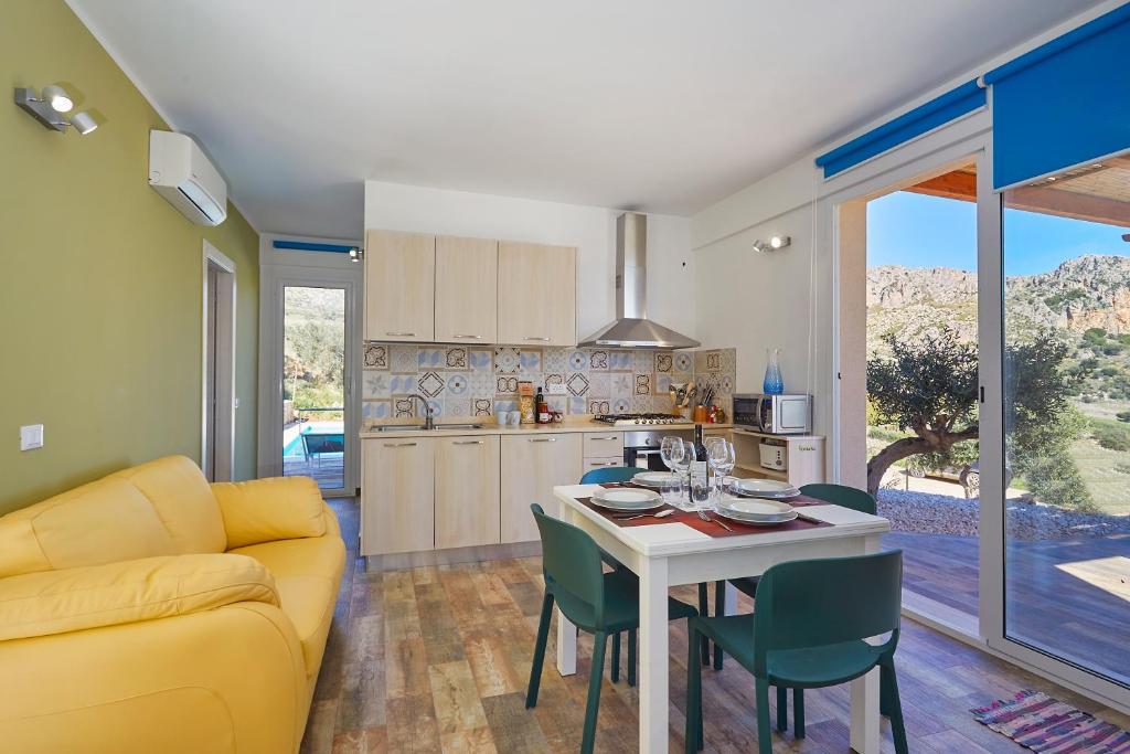 Il comprend une cuisine et un salon avec un canapé jaune et une table. dans l'établissement Villa Montemar, à Balata di Baida