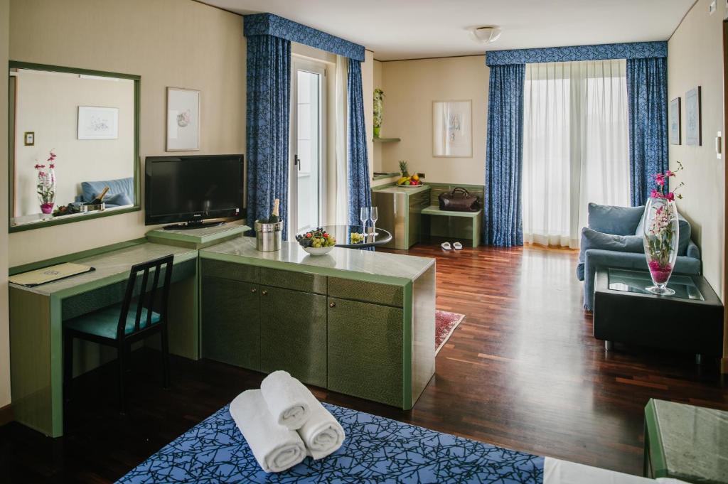 un salon avec un bureau et une télévision dans l'établissement Hotel Royal, à Fermo