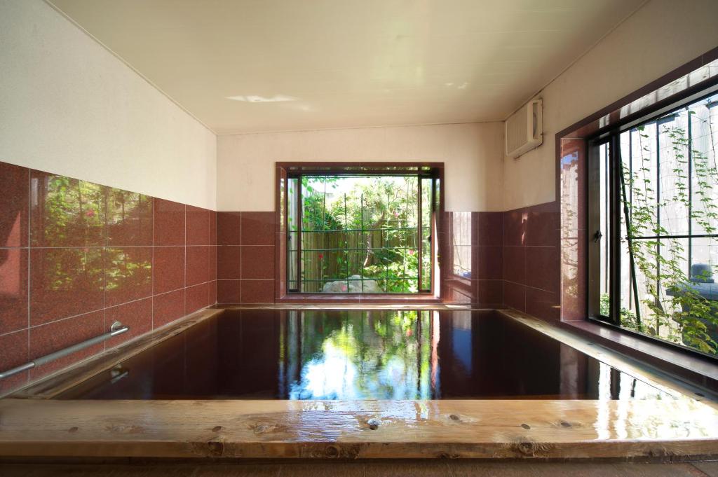 - une piscine vide dans une salle de bains pourvue d'une fenêtre dans l'établissement 黒潮の宿 臨海荘 -Kuroshio no yado Rinkaisou-, à Katsuura