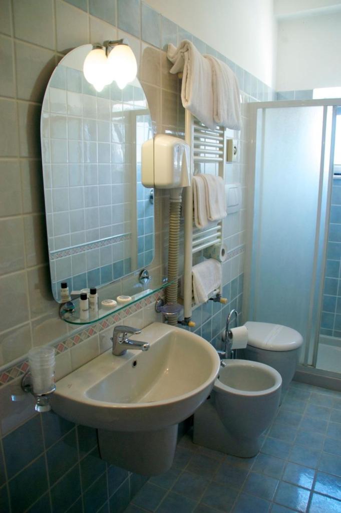 une salle de bain avec un lavabo, des toilettes et un miroir dans l'établissement Hotel Ristorante Anita, à Cupra Marittima 26 autres photos