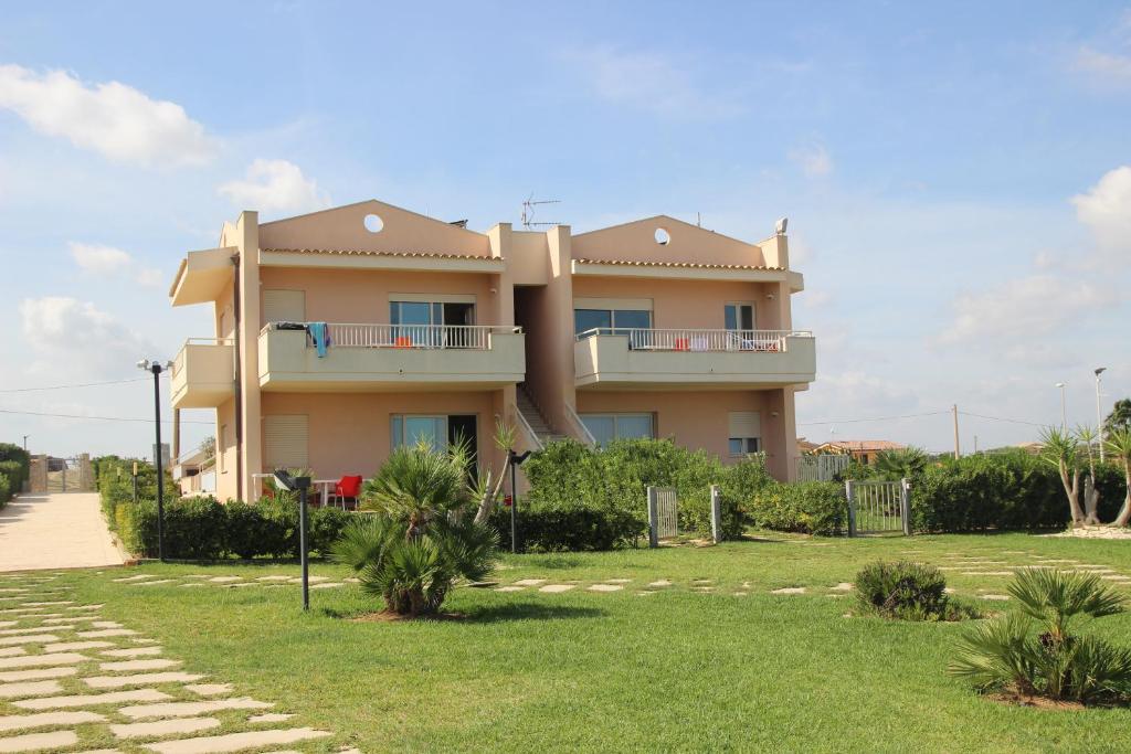 une grande maison avec une pelouse devant dans l'établissement Agua Residence, à Noto