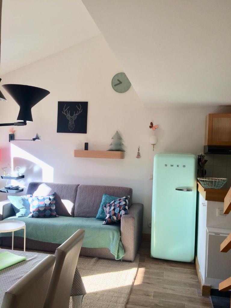 - un salon avec un canapé et un réfrigérateur dans l'établissement Duplex skis aux pieds Belle Plagne, à Belle Plagne