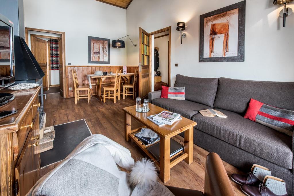 un salon avec un canapé et une table dans l'établissement Village Montana, à Val Thorens