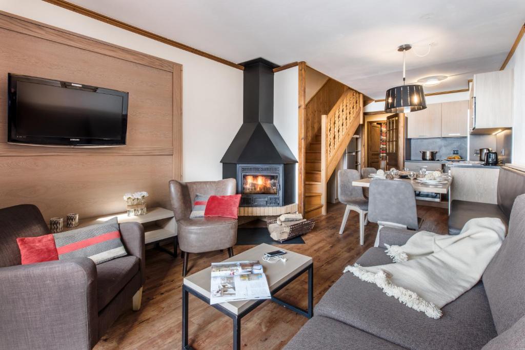 un salon avec un canapé et une cheminée dans l'établissement Village Montana, à Val Thorens