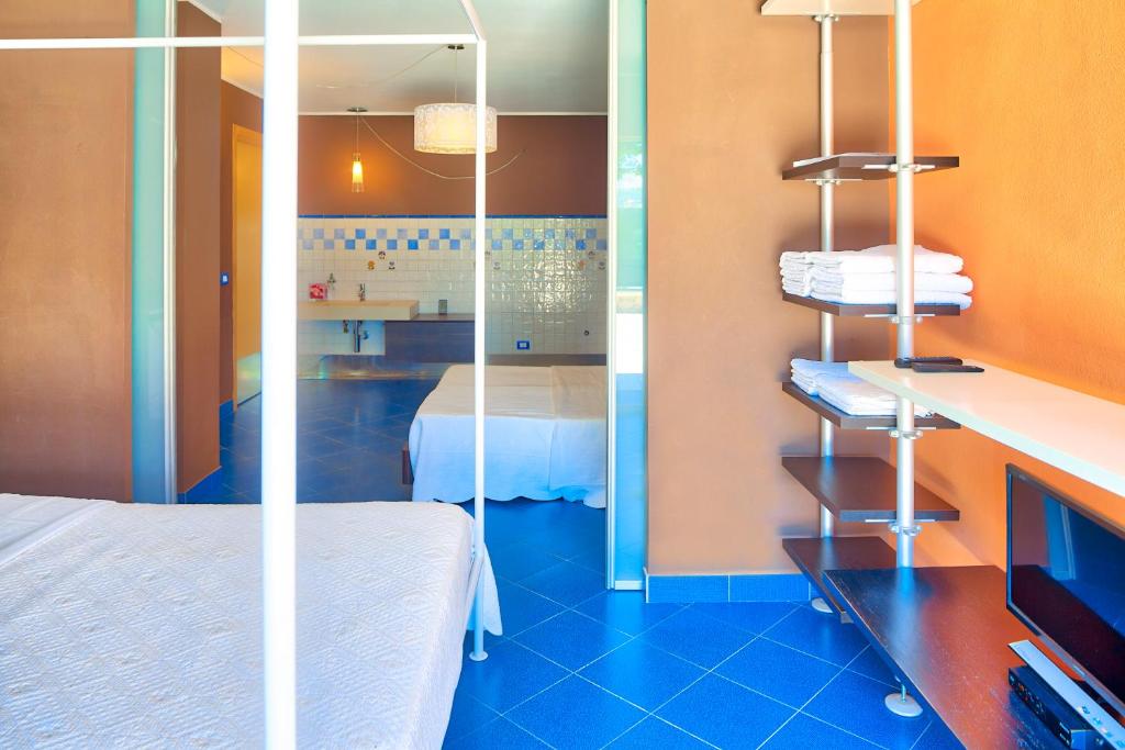 Cette chambre comprend un lit et un miroir. dans l'établissement Villa Emanuele Costarainera, à Costarainera