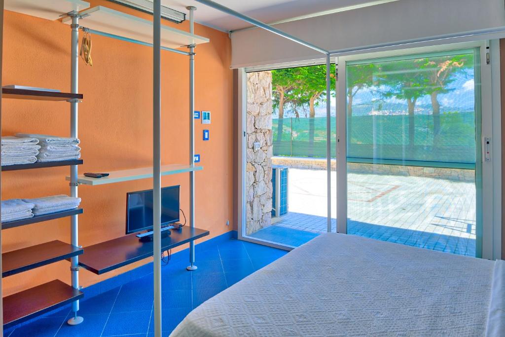 une chambre avec un lit et une porte coulissante en verre dans l'établissement Villa Emanuele Costarainera, à Costarainera 55 autres photos