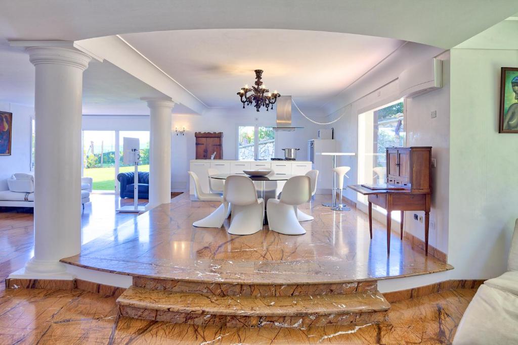 une salle à manger et un salon avec une table et des chaises dans l'établissement Villa Emanuele Costarainera, à Costarainera