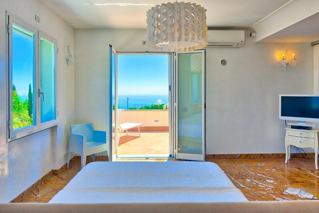 une chambre avec un lit et une vue sur l'océan dans l'établissement Villa Emanuele Costarainera, à Costarainera