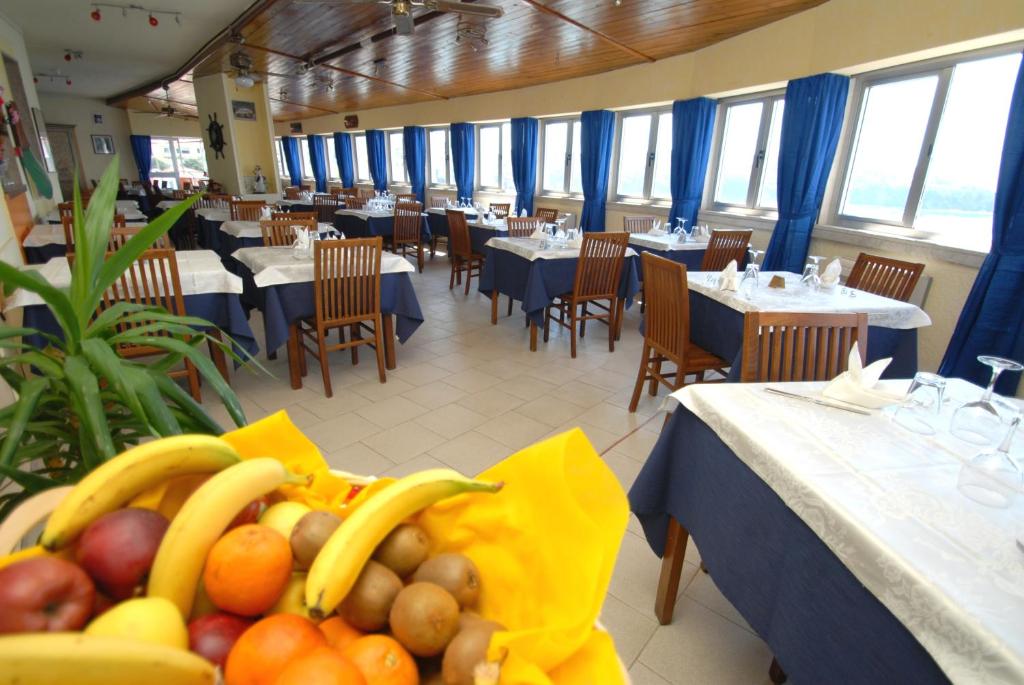 un restaurant avec des tables et des chaises, des bananes et des fruits dans l'établissement Hotel Baia Del Sorriso, à Castiglioncello 71 autres photos