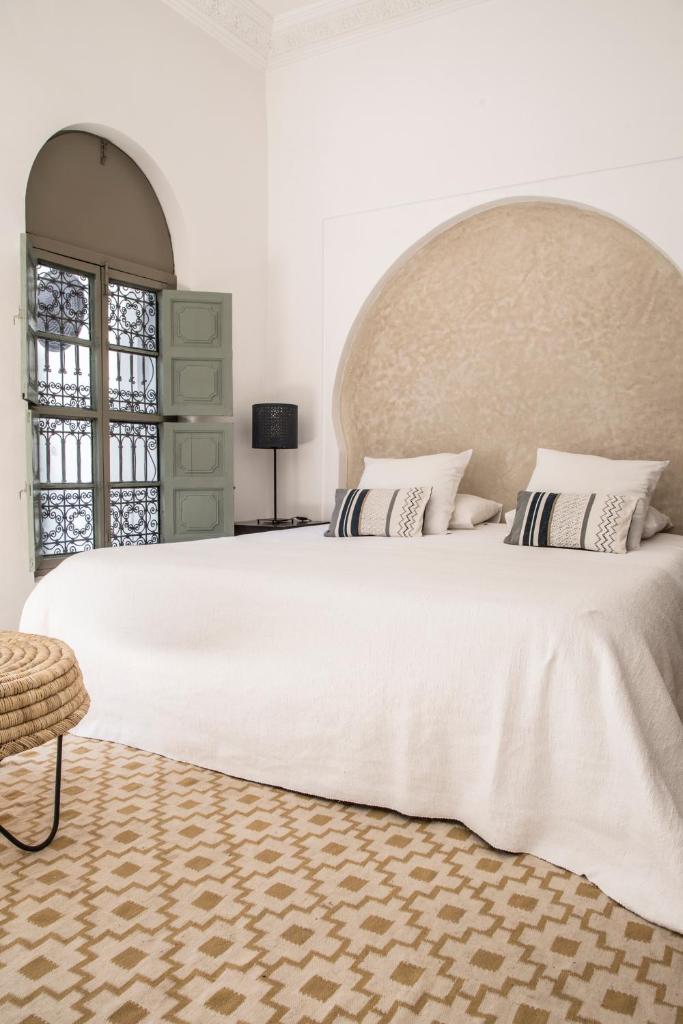 une chambre avec un grand lit blanc avec une grande tête de lit dans l'établissement Riad Danka, à Marrakech