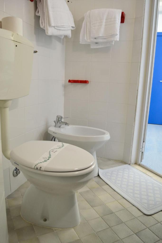 une salle de bain blanche avec toilettes et lavabo dans l'établissement Hotel Playa e Mare Nostrum, à Caorle