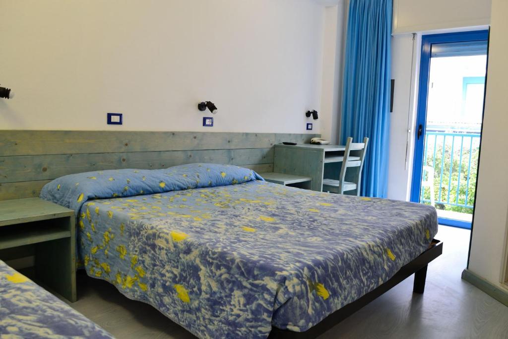 une chambre avec deux lits et une table et une fenêtre dans l'établissement Hotel Playa e Mare Nostrum, à Caorle