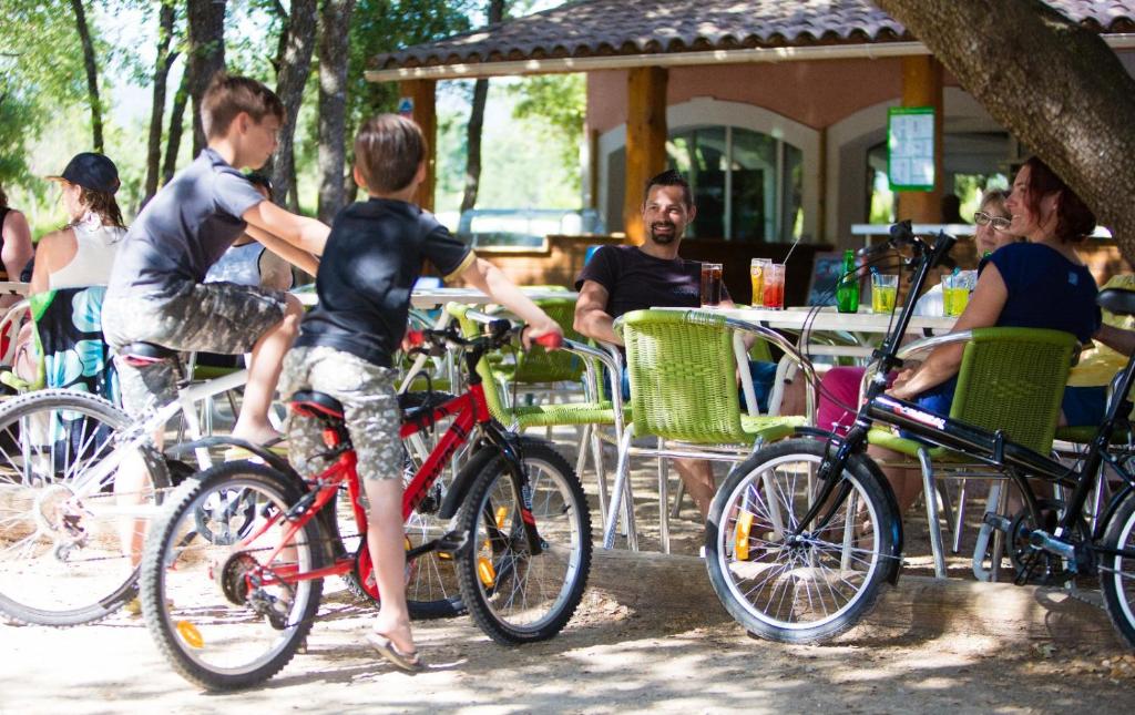 Un jeune garçon faisant un vélo rouge à une table dans l'établissement Domaine Les Chênes Blancs, à Saint-Saturnin-lès-Apt