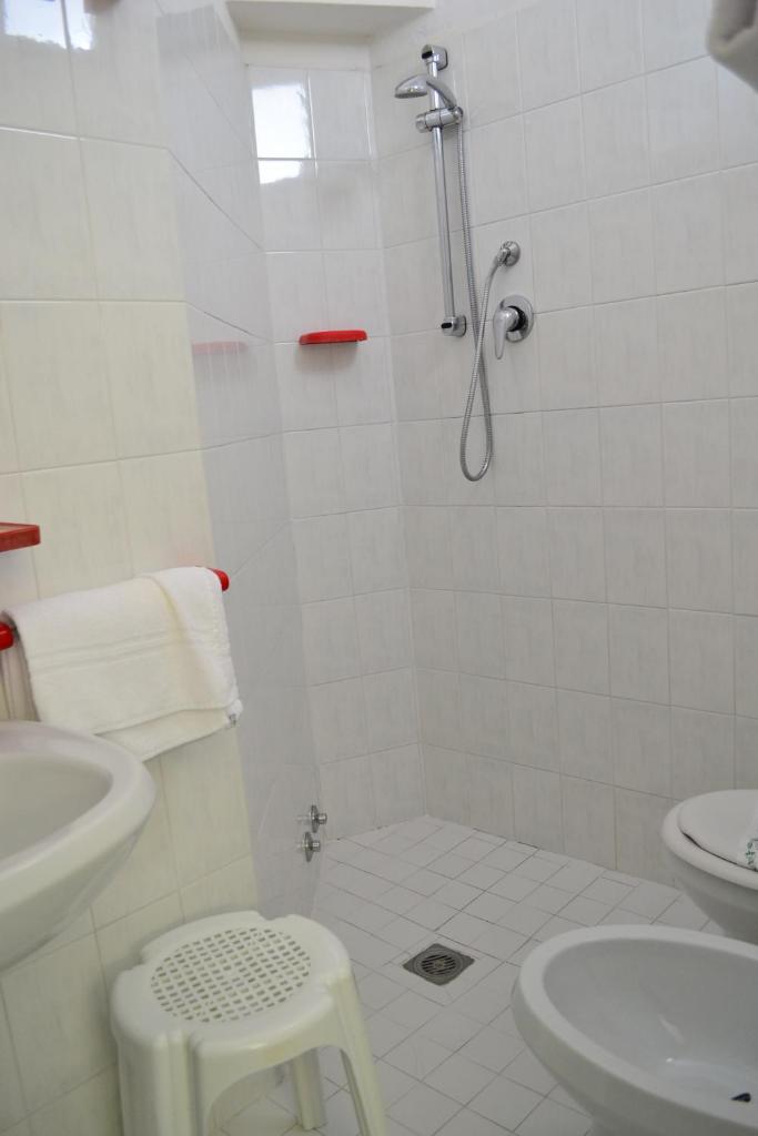 une salle de bain blanche avec une douche et un lavabo dans l'établissement Hotel Playa e Mare Nostrum, à Caorle 18 autres photos