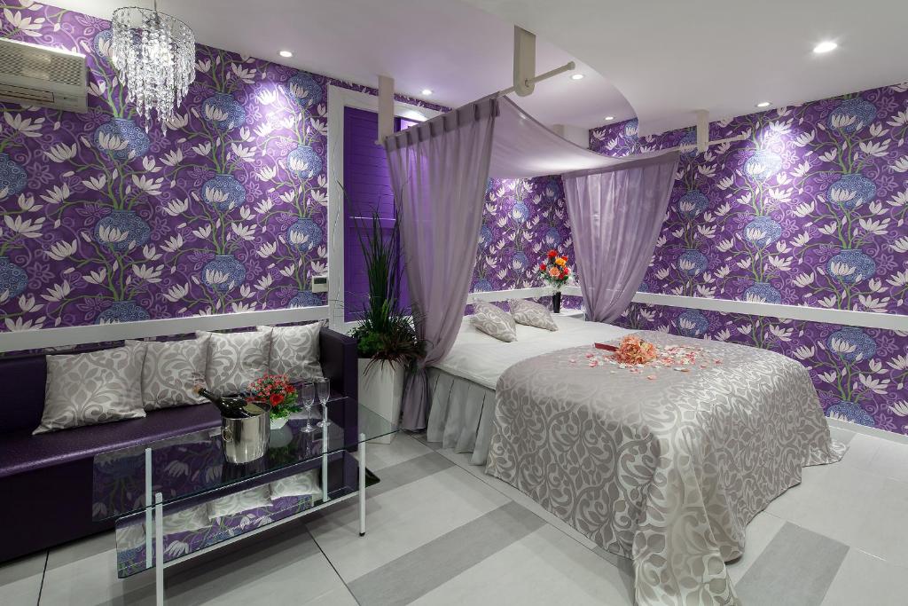 - une chambre violette avec un lit et un mur violet dans l'établissement Restay Okayama (Adult Only), à Okayama