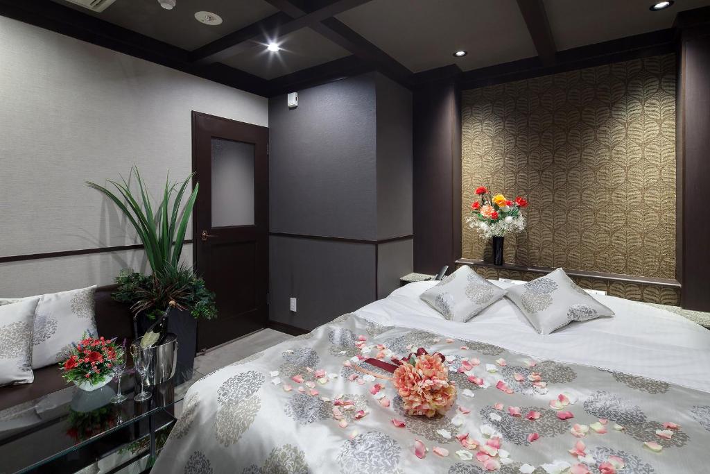 une chambre avec un lit avec des fleurs dessus dans l'établissement Restay Okayama (Adult Only), à Okayama