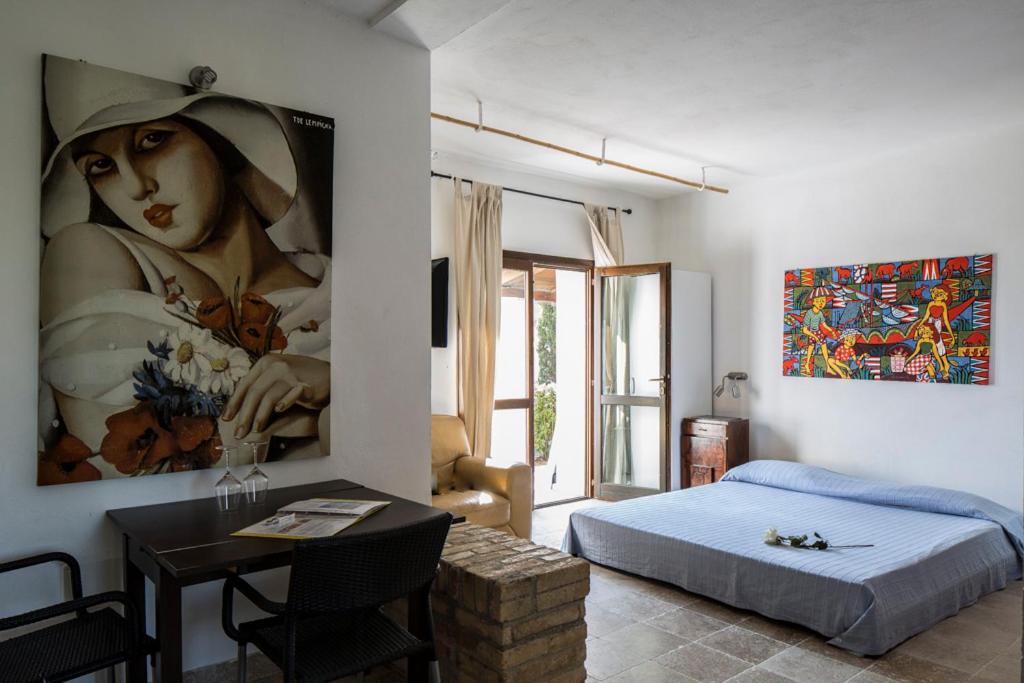 une chambre avec une peinture d'une femme avec un chapeau dans l'établissement Casali Costadoro, à Acquaviva Picena 181 autres photos