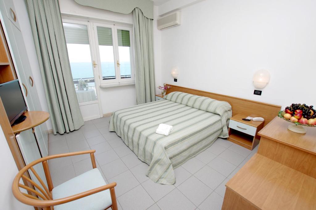 une chambre d'hôtel avec un lit et un bureau dans l'établissement Eurotel, à Grottammare