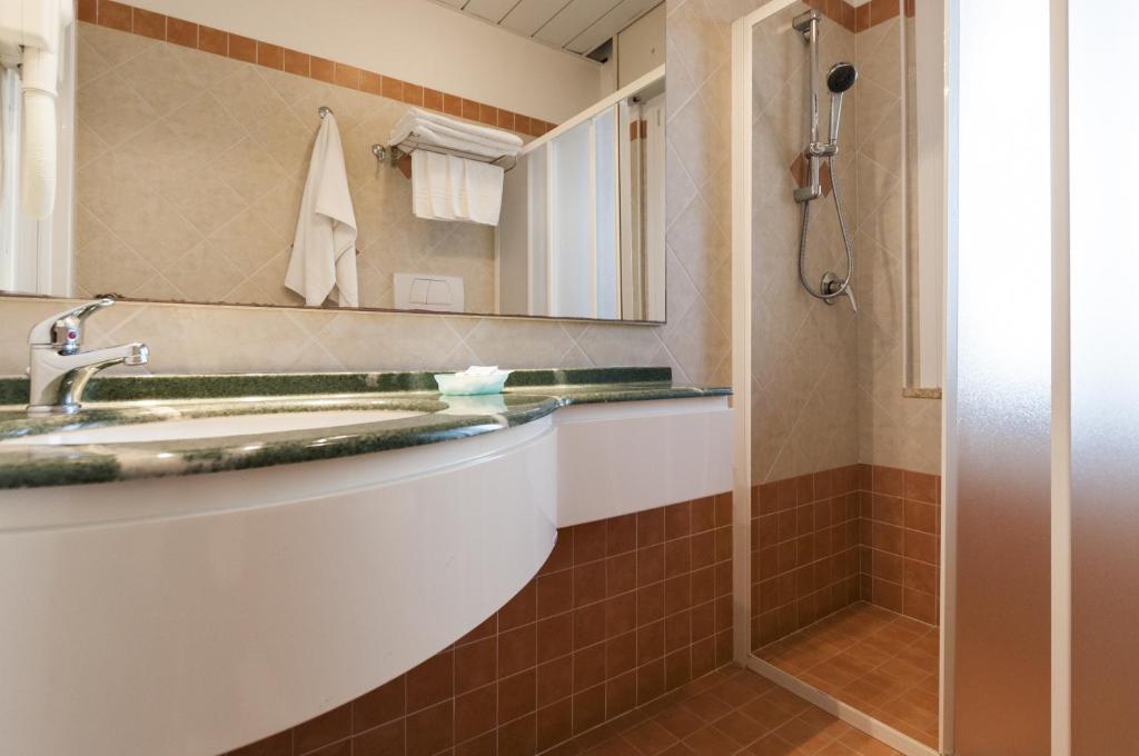 une salle de bain avec un lavabo et une douche dans l'établissement Hotel Donatella Pinarella, à Cervia