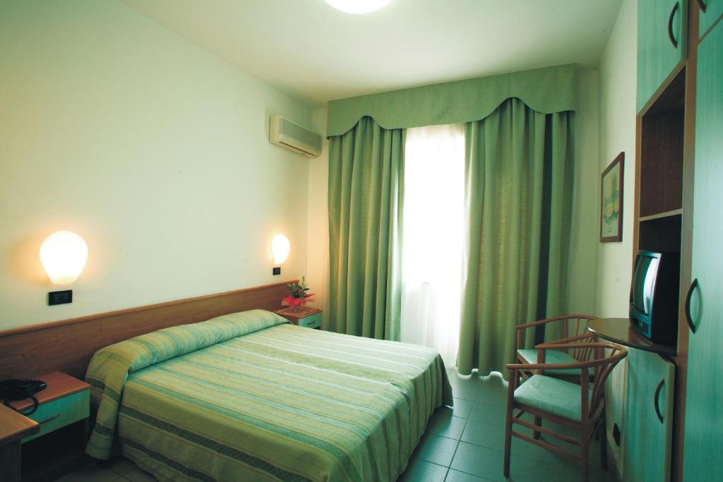 une chambre avec un lit, une fenêtre et une chaise dans l'établissement Eurotel, à Grottammare