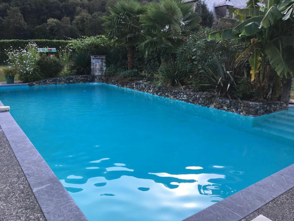une piscine avec de l'eau bleue dans une cour dans l'établissement gite le callisto, à Geu