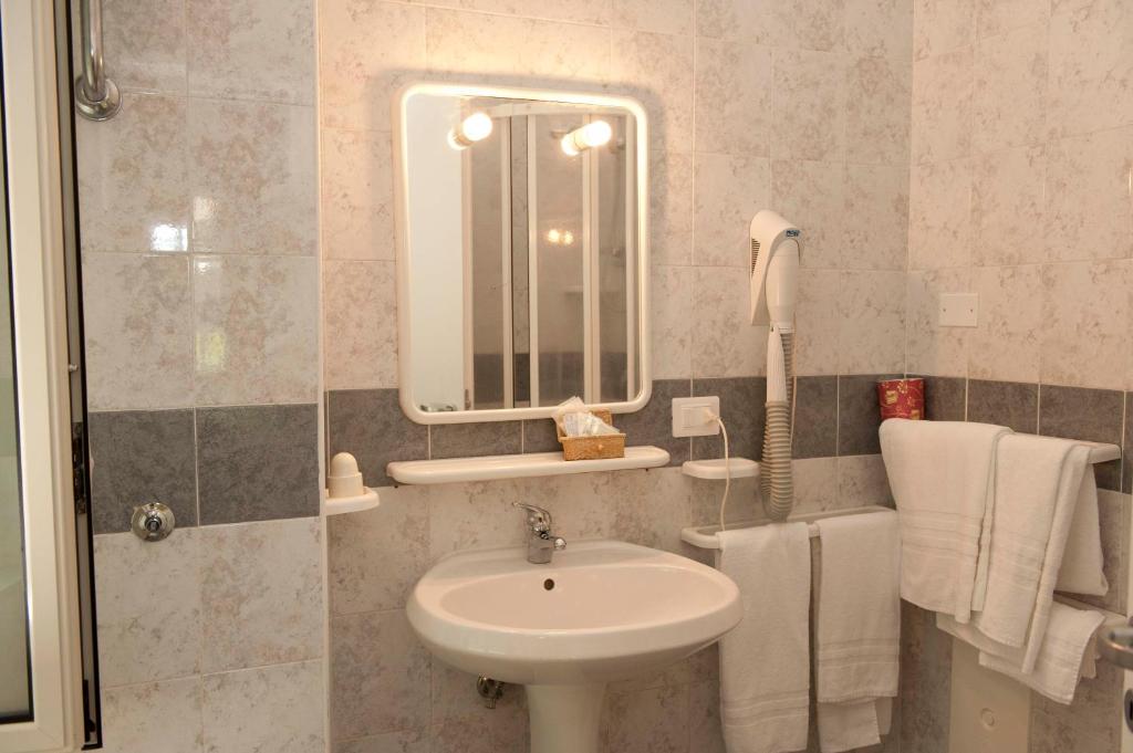 une salle de bain avec un lavabo et un miroir dans l'établissement Hotel Venere, à Ascea 64 autres photos