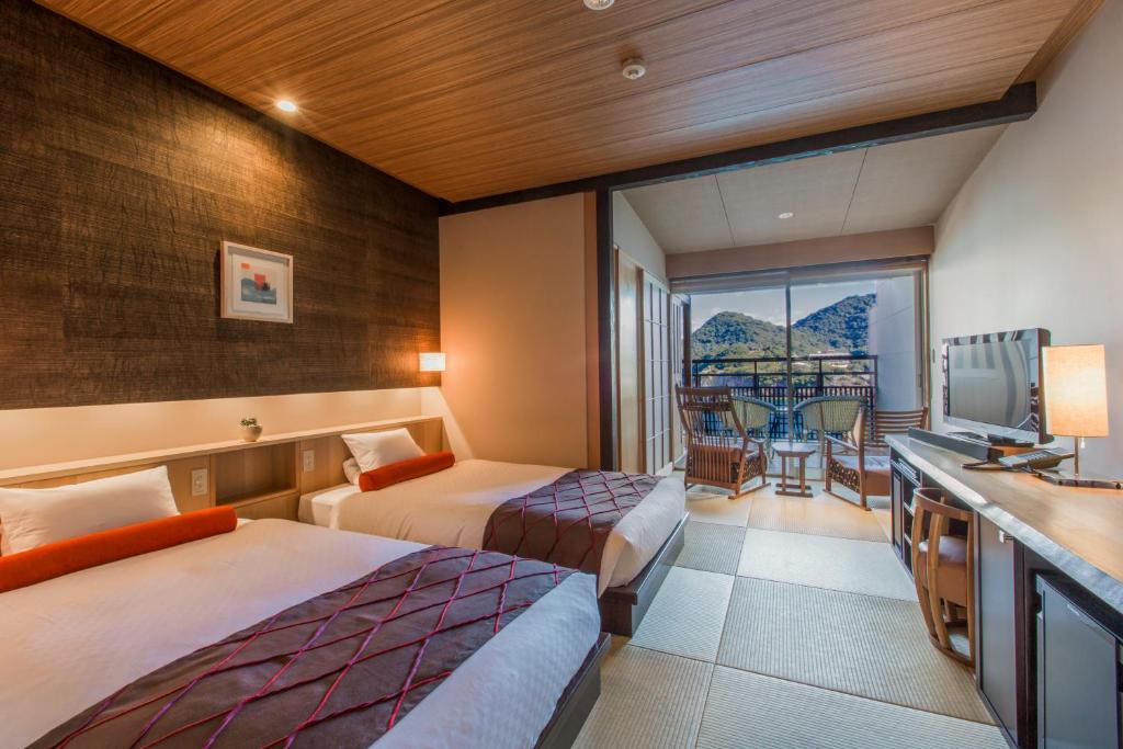 une chambre d'hôtel avec deux lits et un balcon dans l'établissement Migiwatei Ochi Kochi, à Fukuyama 36 autres photos
