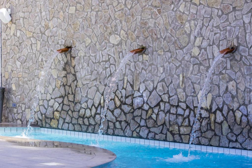 - une piscine avec deux fontaines devant un mur en pierre dans l'établissement Hotel Le Axidie, à Vico Equense 59 autres photos
