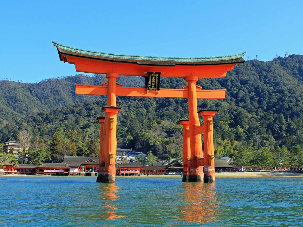 un portail orange au milieu de l'eau dans l'établissement Kimatsu Ryokan, à Hiroshima