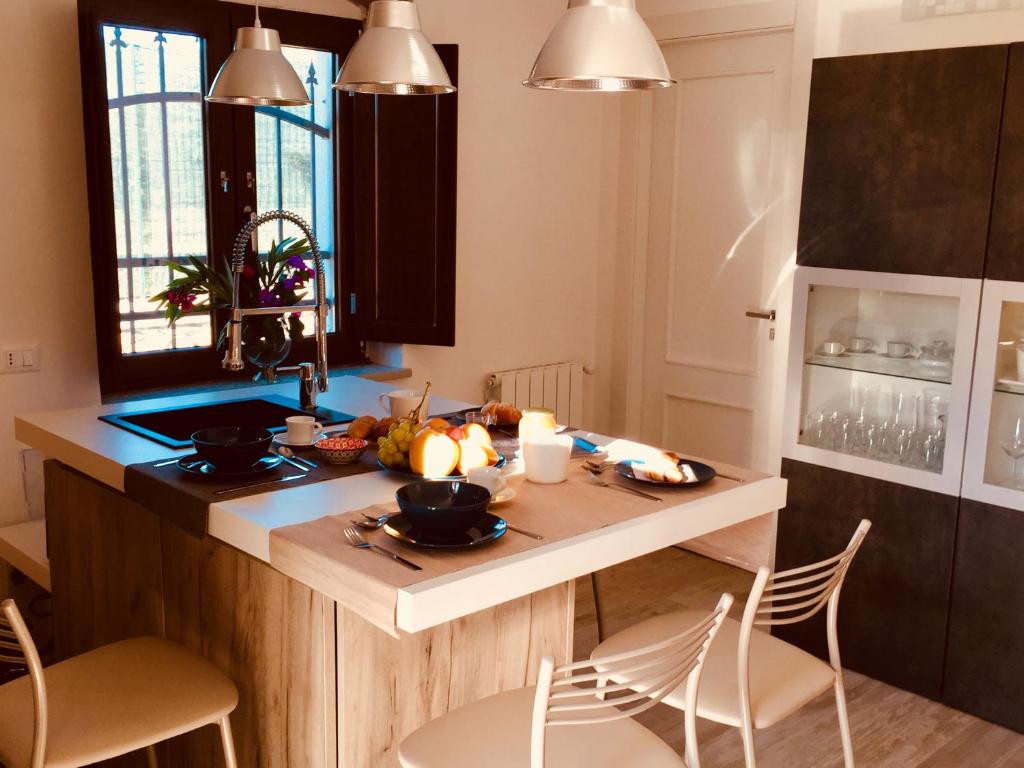 une cuisine avec un comptoir, une table et des chaises dans l'établissement flAle's holiday house, à Cefalù