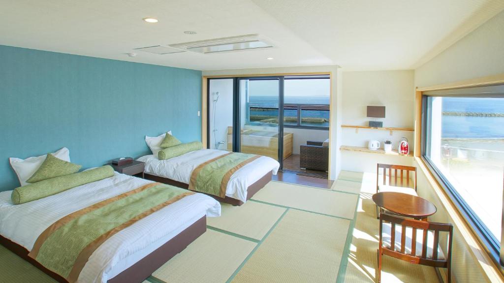 une chambre d'hôtel avec deux lits et un balcon dans l'établissement SEVEN SEAS HOTEL ITO (セブンシーズホテル）, à Itō