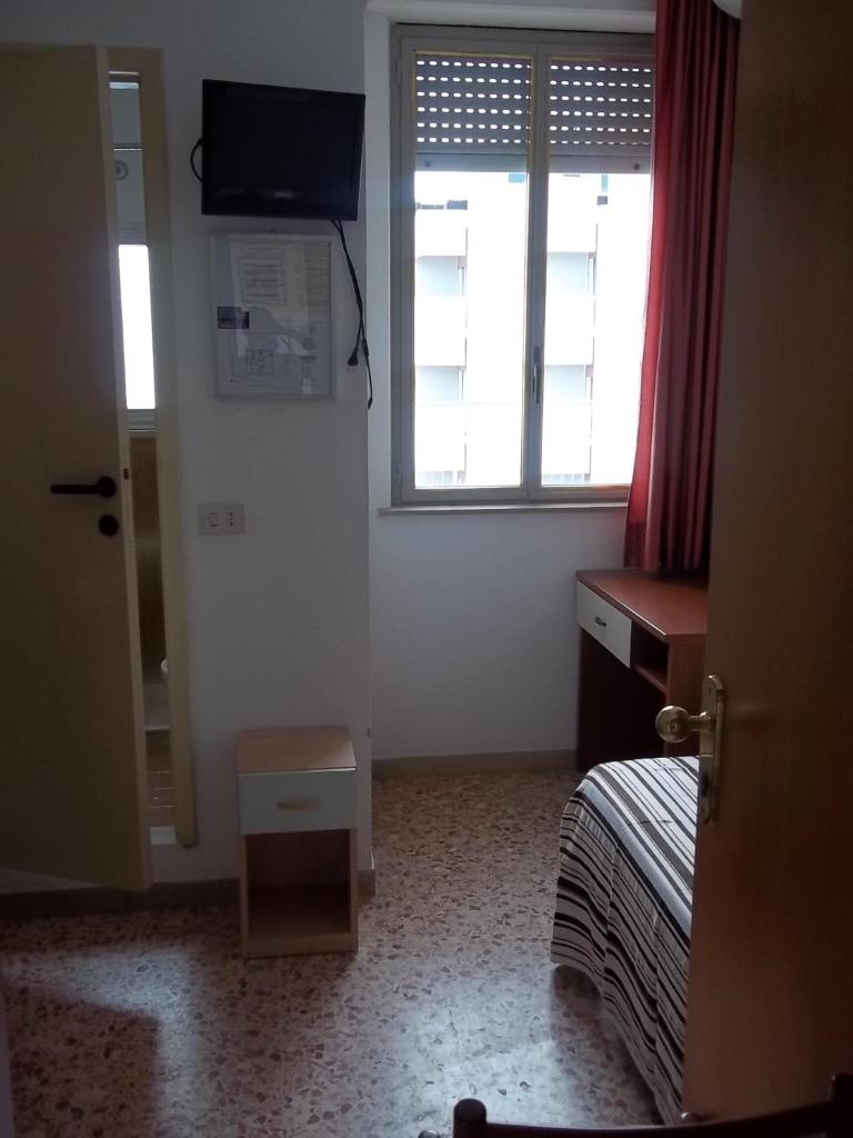 une chambre avec un lit, une télévision et une fenêtre dans l'établissement Hotel Italia, à Senigallia