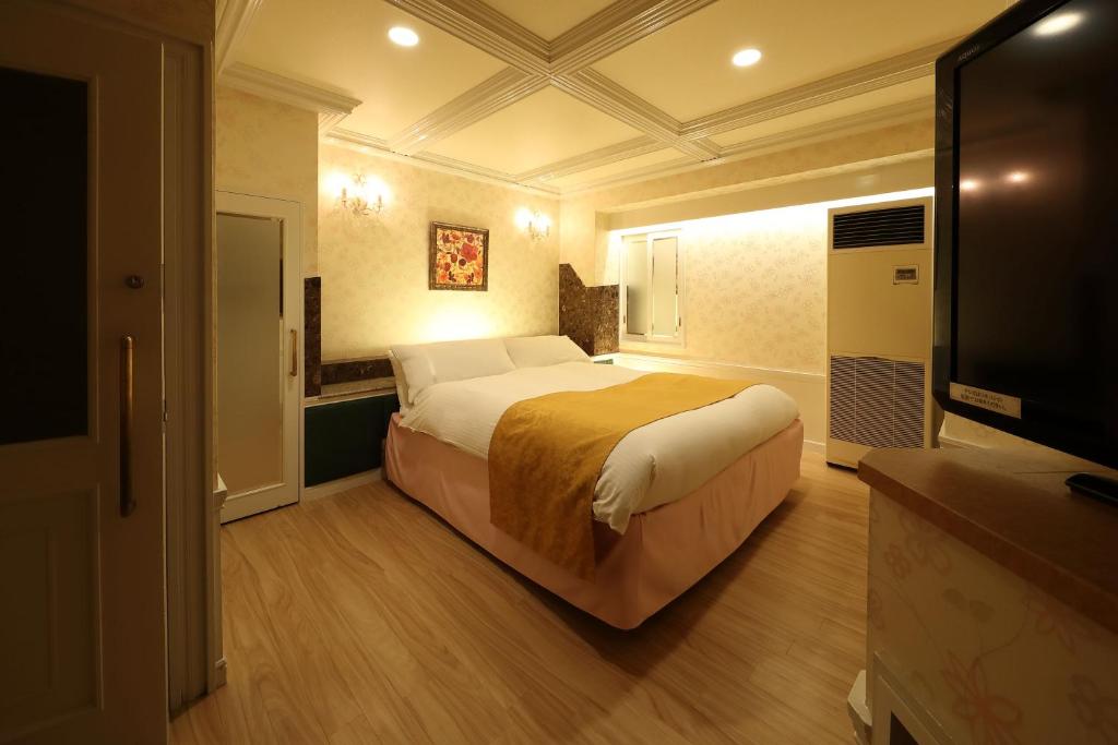 une chambre avec un lit et une télévision à écran plat dans l'établissement Hotel Fine Garden Okayama I, à Okayama