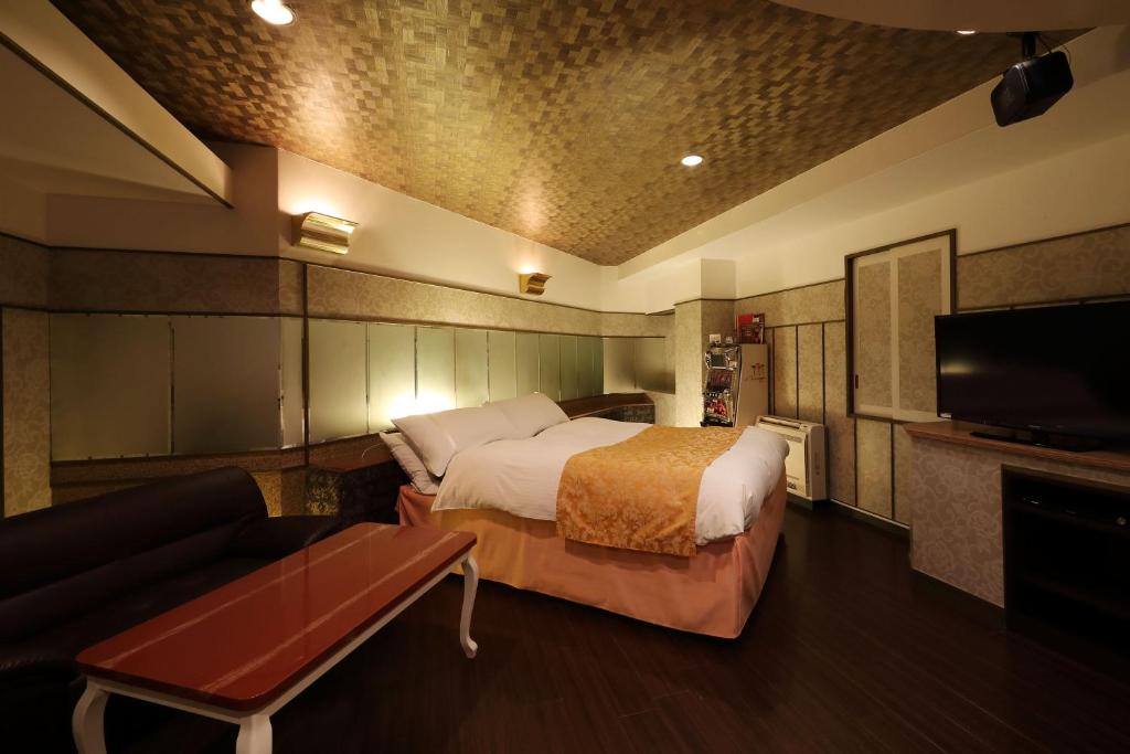 une chambre avec un lit, un canapé et une télévision dans l'établissement Hotel Fine Garden Okayama I, à Okayama 14 autres photos