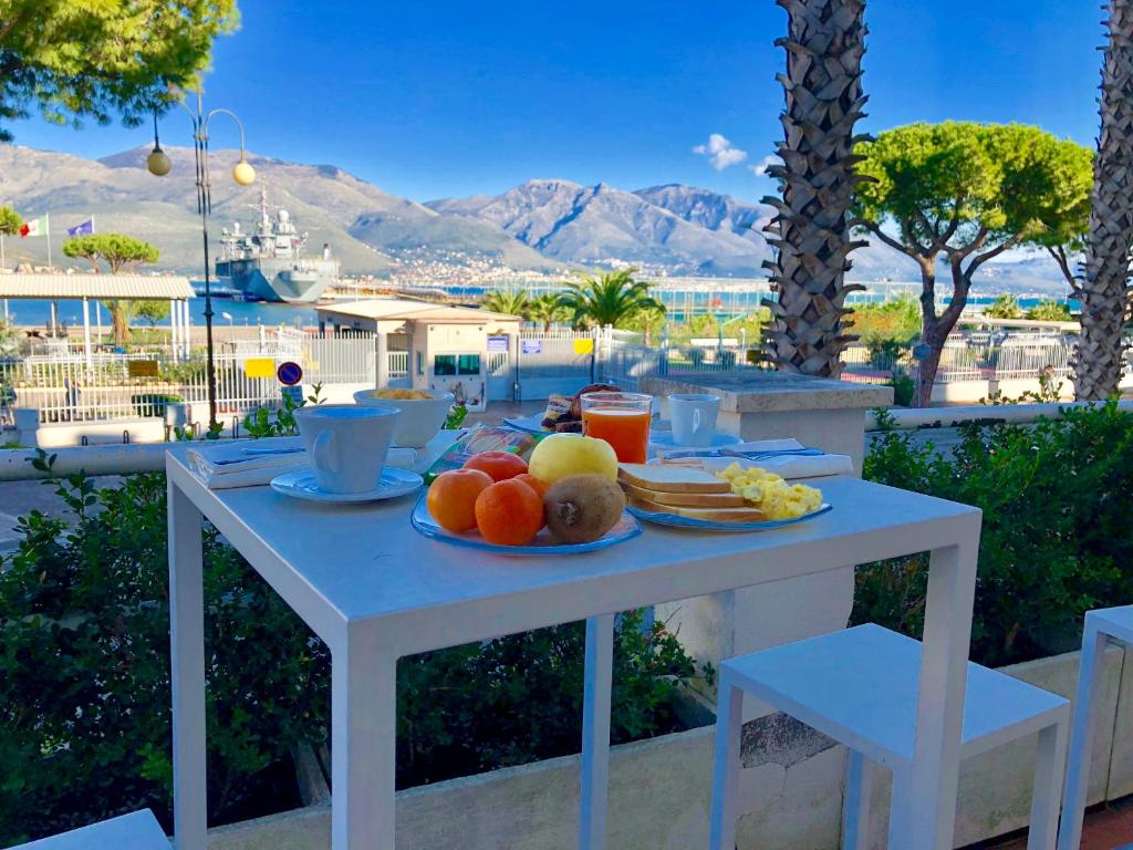 une table blanche avec une assiette de fruits sur elle dans l'établissement Hotel Gajeta, à Gaète 72 autres photos