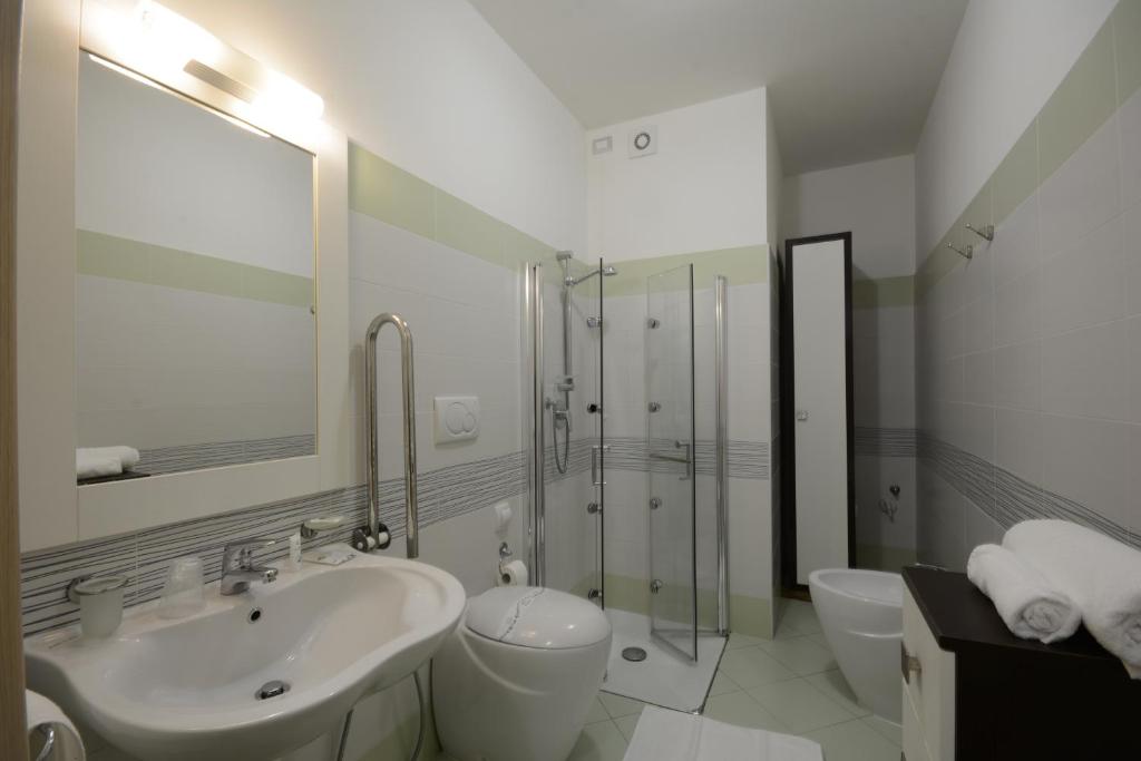 une salle de bain avec un lavabo, des toilettes et une douche dans l'établissement Kiara Residence, à Giulianova