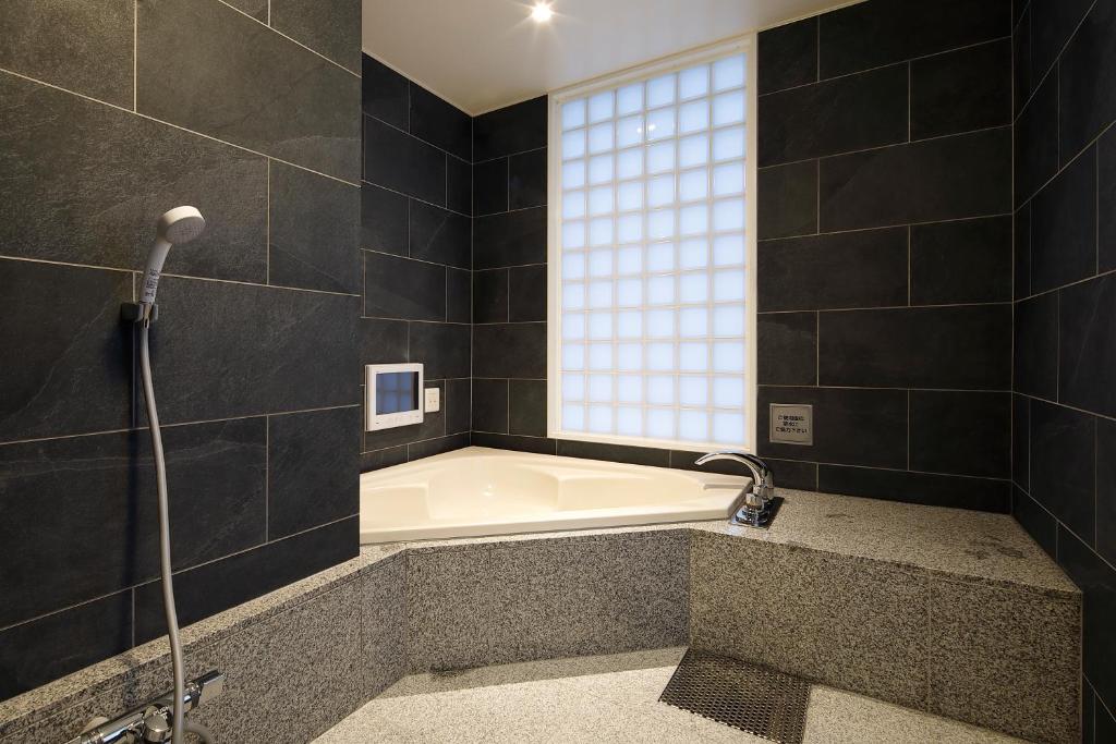 une baignoire dans une salle de bain avec une fenêtre dans l'établissement Hotel ValentineTogo (Adult Only), à Togo 38 autres photos