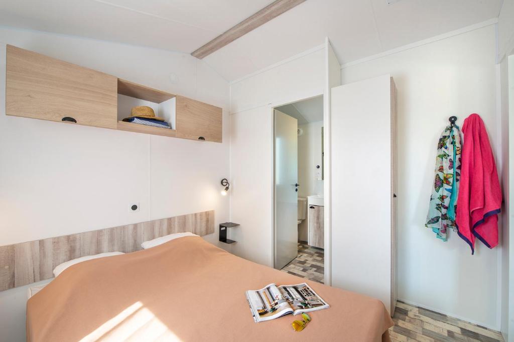 une petite chambre avec un lit et un miroir dans l'établissement Camping Bel Air, à Les Sables-dʼOlonne
