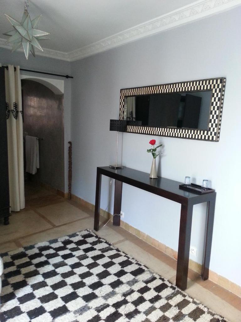 - un salon avec une table et un miroir dans l'établissement Riad AZZA, à Marrakech