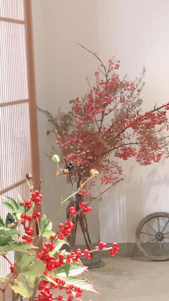 un vase avec une plante avec des fleurs rouges dans l'établissement Auberge AZABU, à Kyoto