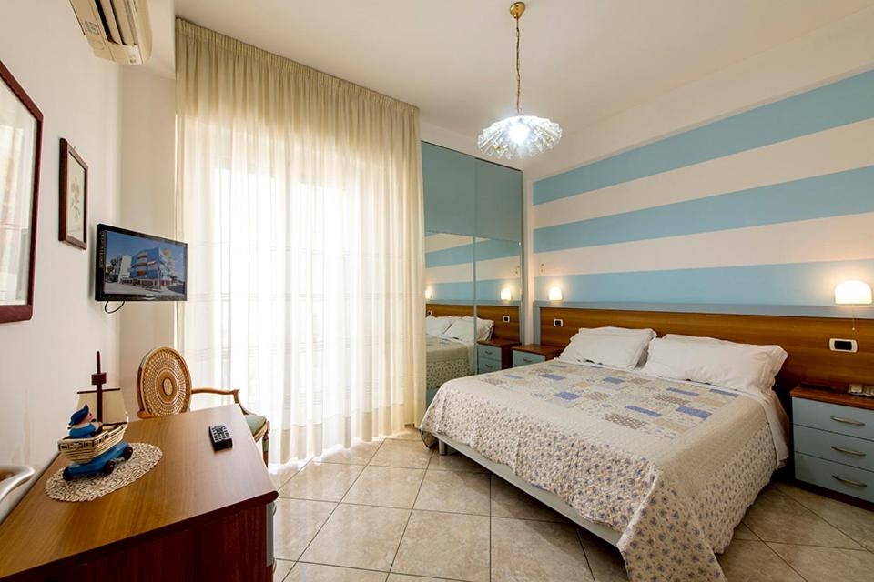 une chambre avec un lit, un bureau et une fenêtre dans l'établissement Hotel Le Soleil, à San Benedetto del Tronto