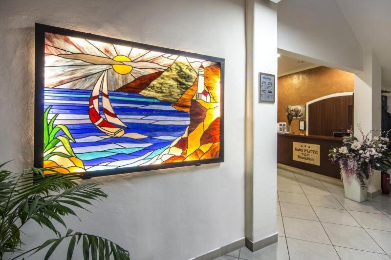 une grande peinture en vitrail sur un mur dans un couloir dans l'établissement Hotel Playa, à Viareggio